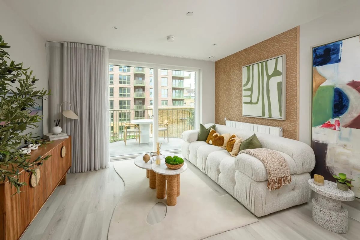 Show apartment living room with a white boucle sofa, a timber sideboard, a large abstract canvas and doors to the balcony